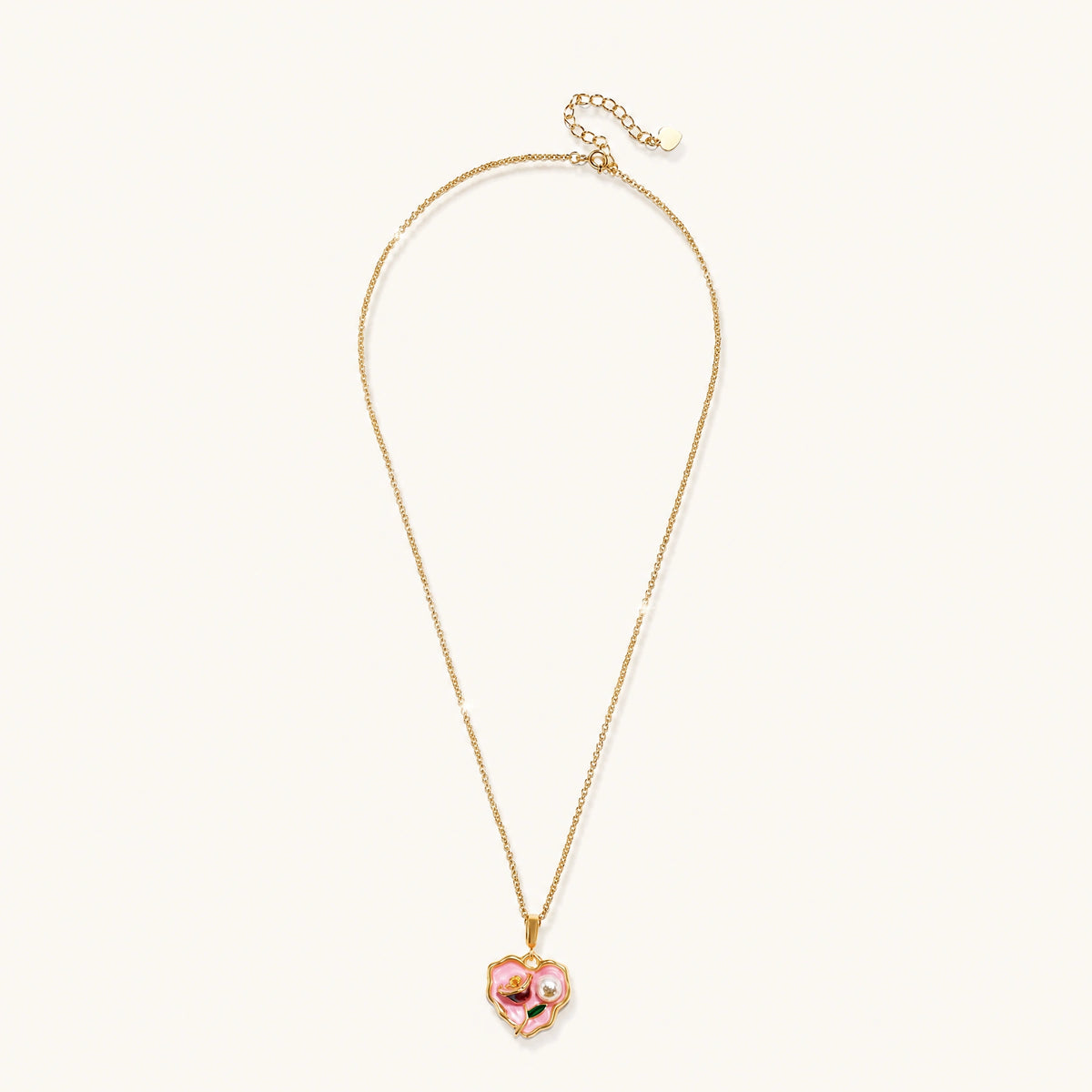 Heart-shaped pendant with pink enamel, rose design, freshwater pearl flower, and gold scalloped frame on delicate chain